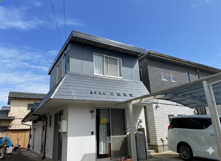 ブルーグレーと白のツートン外壁に塗装された戸建て住宅