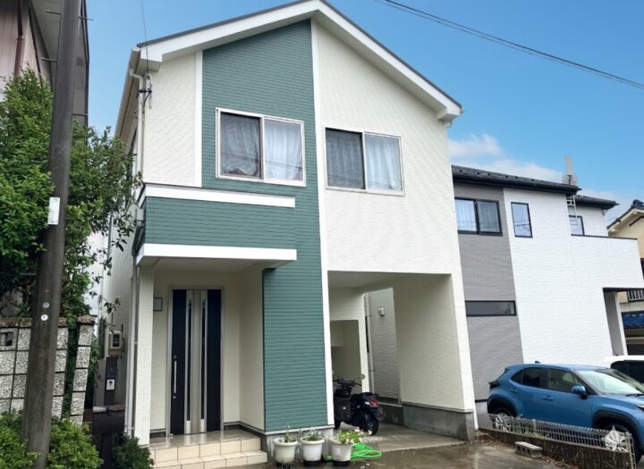 くすみグリーンと白のツートンで外壁塗装した戸建て住宅
